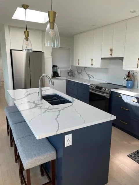 Two-tone kitchen with blue island and white upper cabinets