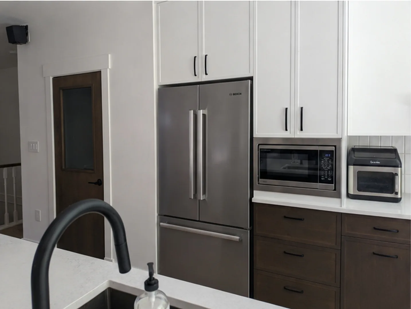 Finished fridge wall with custom pivot pantry door